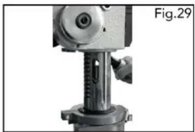 Close-up of a mechanical press or drill bit with a hand operating the shaft (no visible text or symbols)