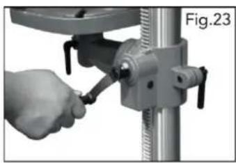 Close-up of a hand using a tool to adjust or install a mechanical component, labeled Fig.23 (no text on the object itself)