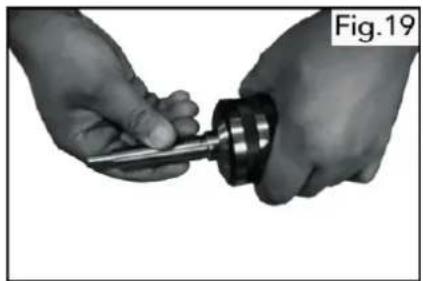 Close-up of hands holding a tool with a mechanical component, labeled Fig.19 (no text or symbols on the tool itself)
