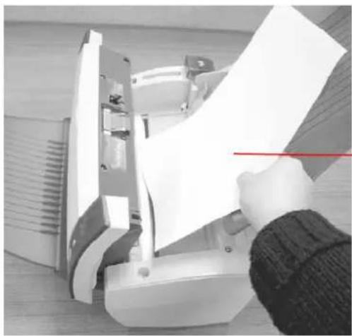 Person using a paper tool to lift a white plastic door (no text or symbols visible)