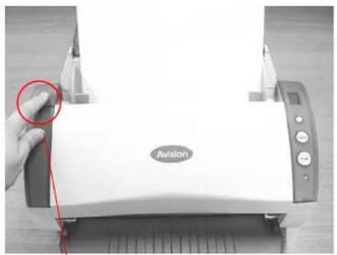 Close-up of a white Atlas V89 printer with a hand pointing to its paper edge, no visible text or symbols on the device itself.