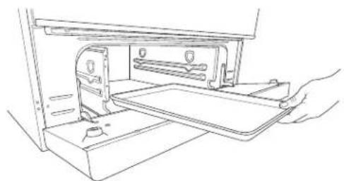 Line drawing of a hand inserting a tray into a device (no text or symbols)