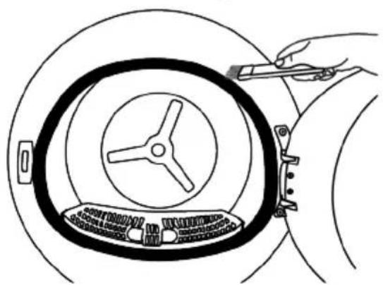 Line drawing of a hand holding a tool interacting with a circular mechanical component (no text or symbols)