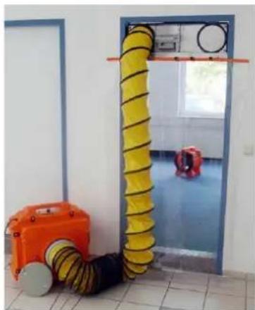 Interior view of a room with yellow and orange cables, a blue door, and a small red safety device (no visible text or symbols)