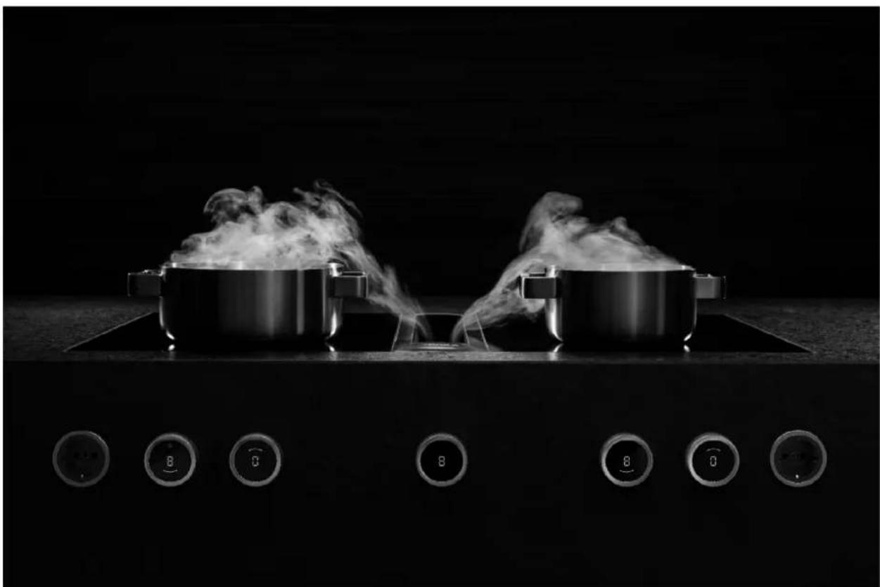 Black-and-white photo of two cooking pots on a stovetop with steam rising, surrounded by control buttons (no text or symbols visible)