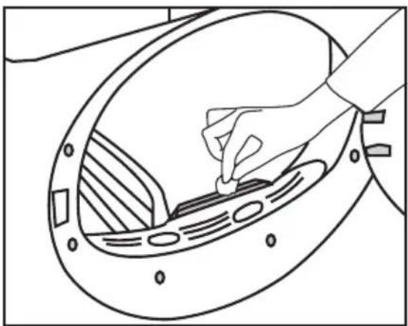 Line drawing of a hand inserting a small component into a circular device (no text or symbols)