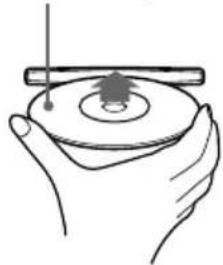 Illustration of a hand holding a circular object with a pointer and a small tree-like symbol on the ring (no text or symbols present)