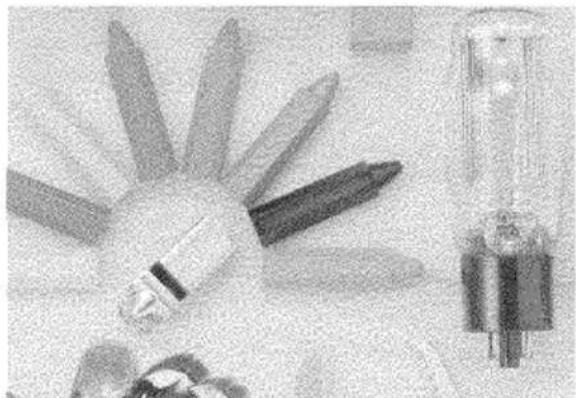 Black-and-white photo of a set of paper cutters and a syringe on a surface (no visible text or symbols)