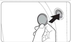 Hand holding a circular button with an arrow pointing to the button (no text or symbols visible)