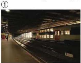Interior view of a train station platform with multiple tracks and illuminated windows (no visible text or signage)