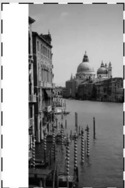 Black-and-white photo of a Venetian canal with historic buildings and a large domed cathedral in the background (no visible text or symbols)