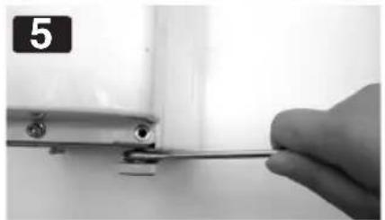 Close-up of a hand holding a screwdriver inserted into a small mechanical component (no text or symbols visible)