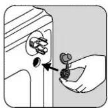 Hand holding a small object with a knob, pointing to a button (no text or symbols visible)