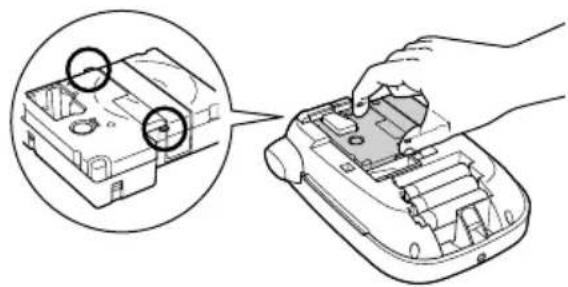 Illustration of a hand inserting a component into a device casing, with magnified inset showing two circular components (no text or symbols)