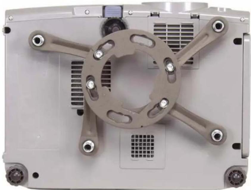 Close-up of a mechanical device with a central circular component and four metal arms (no visible text or symbols)