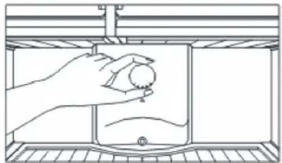 Line drawing of a hand holding a small object inside a container (no text or symbols)