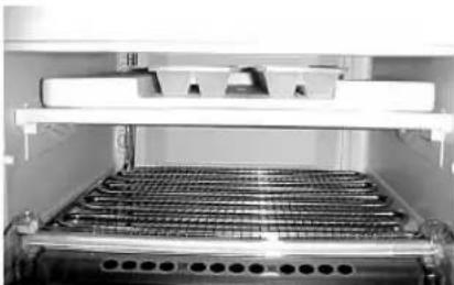 Interior view of a laboratory or industrial storage unit with metal grating and a rack (no visible text or symbols)