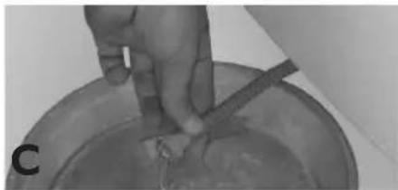 Close-up of a hand holding a tool over a bowl with a small object inside (no visible text or symbols)