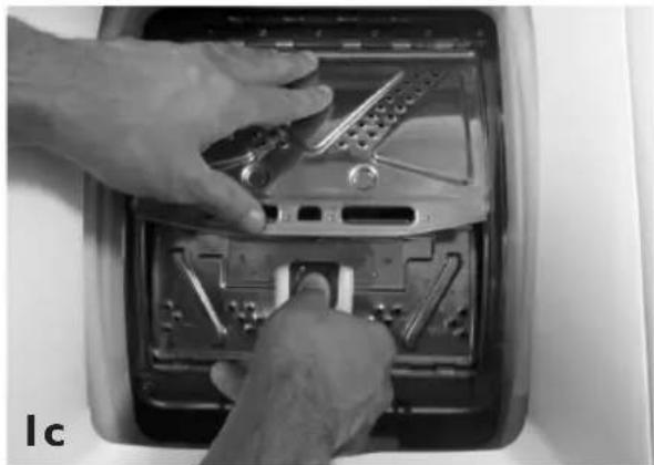 Close-up of hands installing or adjusting a mechanical component on an open car intake tray (no visible text or symbols)