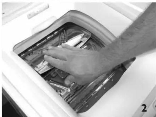 Close-up of a hand cleaning a washing machine with plastic components (no visible text or symbols)