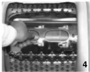 Close-up of a mechanical component with a hand holding a tool, showing internal components and a grid pattern (no visible text or symbols)