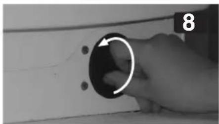 Close-up of a hand holding a circular knob with an arrow, pointing to a button (no text or symbols visible)