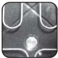 Close-up of a metallic surface with curved and straight lines, featuring a central circular spot (no text or symbols visible)