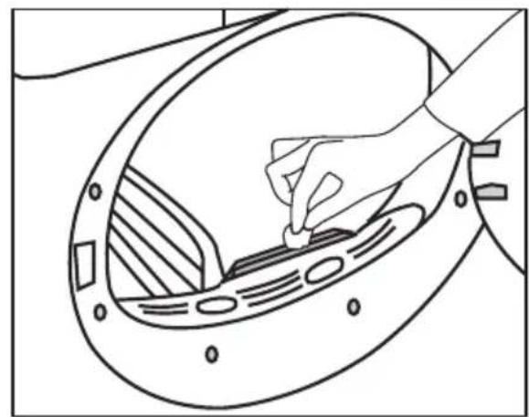 Line drawing of a hand inserting a component into a circular device with internal components (no text or symbols)