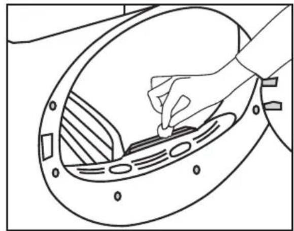 Line drawing of a hand inserting a small component into a circular device (no text or symbols)