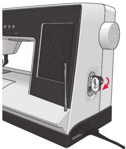 Illustration of a sewing machine with a black panel and control knob, showing no text or symbols on the device itself.