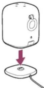 Simple line drawing of a device with a handle and base, showing a downward arrow pointing to a small circular component (no text or symbols)