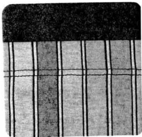 Close-up of a textured surface with vertical black and gray stripes, no visible text or symbols