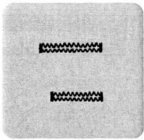 Two identical black zigzag patterns on a textured gray background, no text or symbols present.
