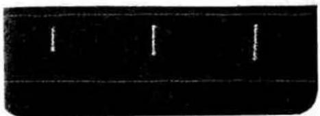 Dark rectangular object with three vertical white lines on a horizontal line, no text or symbols visible.