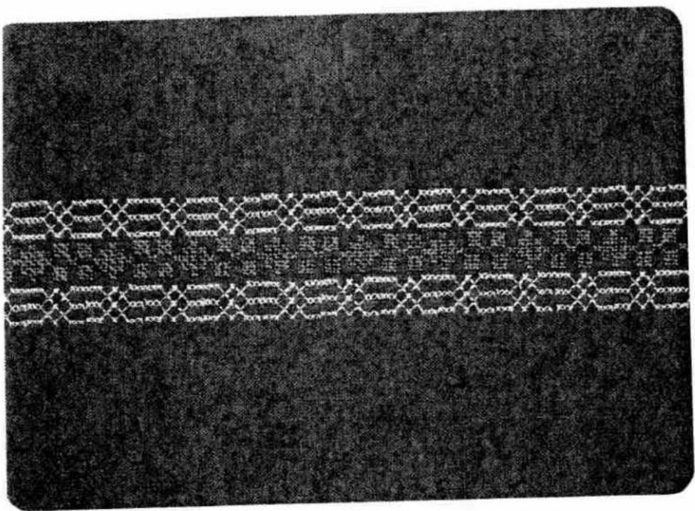 Black-and-white patterned fabric with repeating diamond and square motifs, no text or symbols visible