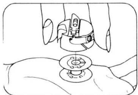 Line drawing of a hand holding a sewing machine over a circular base (no text or symbols)