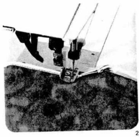 Close-up of a mechanical device with attached components, possibly a tool or clamp, against a textured surface (no visible text or symbols)
