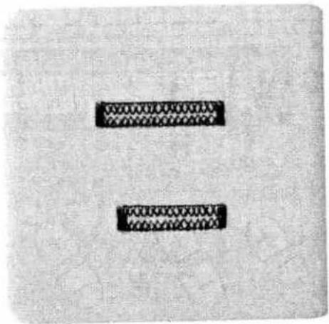 Two black rectangular blocks with textured, patterned edges on a light gray background (no text or symbols)