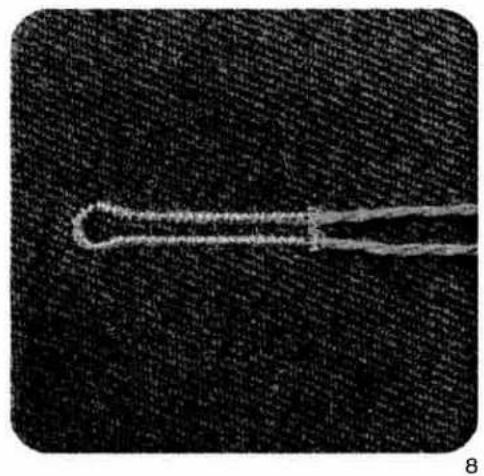 Close-up of a thin, elongated object against a dark textured background (no visible text or symbols)