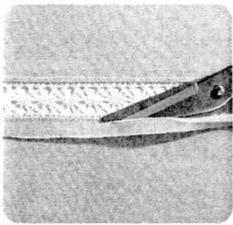 Close-up of a pair of scissors cutting through a metal sheet (no text or symbols visible)