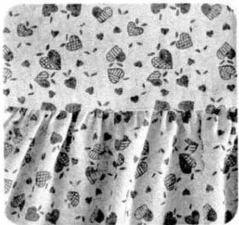 Black and white photo of a patterned fabric with heart-shaped designs on a light background (no text or symbols)