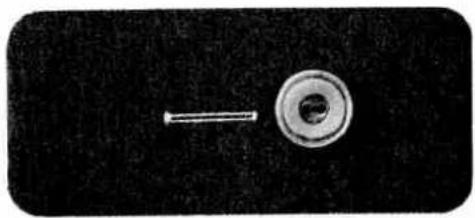 Close-up of a metallic screw and a circular mechanical component on a dark background (no text or symbols visible)