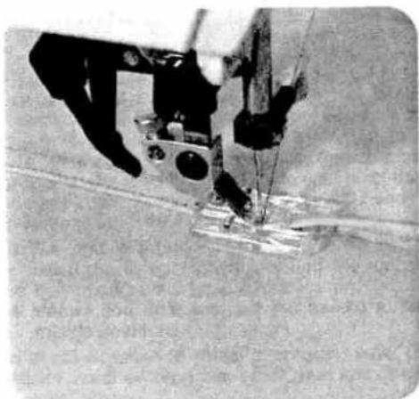 Close-up of a sewing machine needle stitching fabric (no visible text or symbols)
