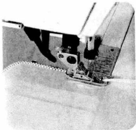 Close-up of a sewing machine needle stitching fabric (no visible text or symbols)
