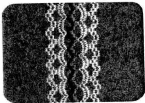 Abstract pattern of white zigzag lines on a dark textured background (no text or symbols)