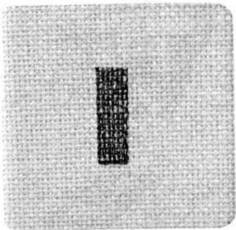 Cropped image showing a vertical black text block on a textured gray background, likely from a document or label.