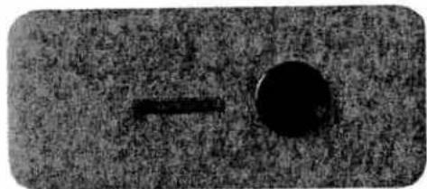Close-up of a dark circular object with a horizontal line and arrow, no visible text or symbols