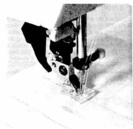Close-up of a sewing machine needle stitching fabric (no visible text or symbols)