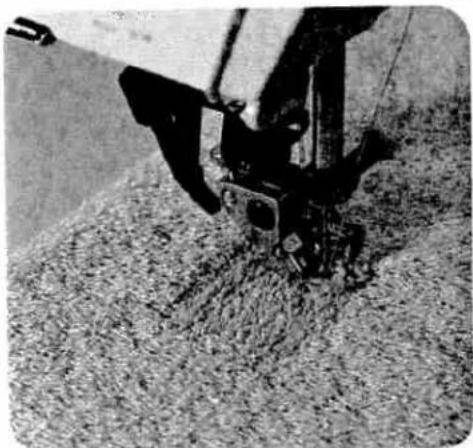 Close-up of a sewing machine stitching fabric (no visible text or symbols)