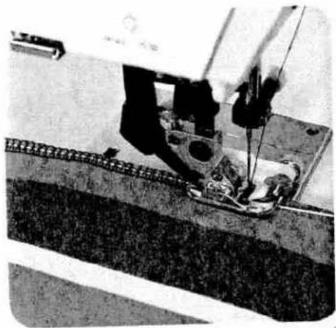 Close-up of a sewing machine needle stitching fabric (no visible text or symbols)